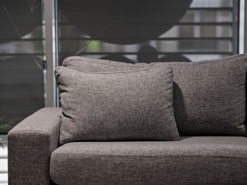 Technician meticulously cleaning couch upholstery